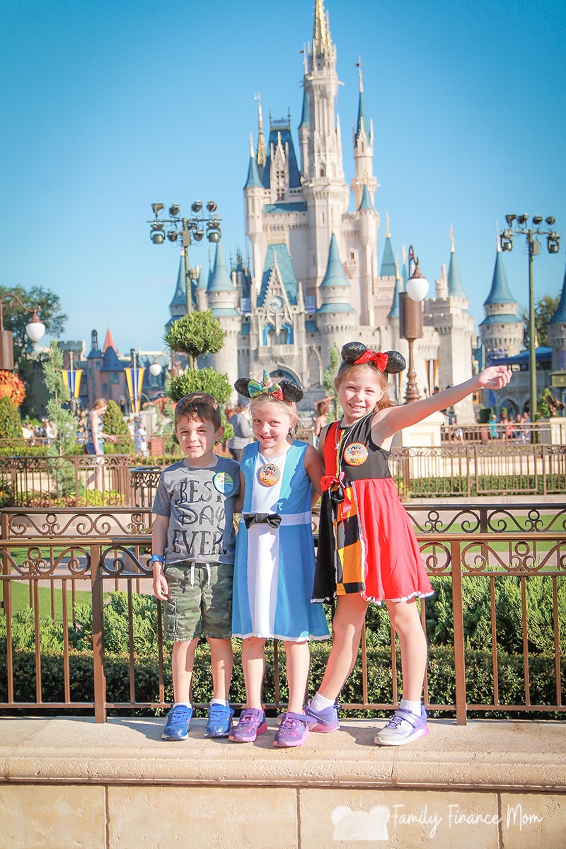 Three kids in front of Cinderella's castle at Disney World