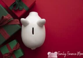 Festive Christmas financial savings concept. White piggy bank money box with presents.